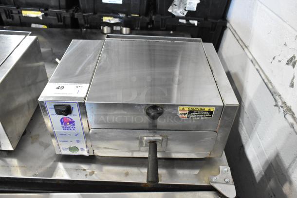 AJ Antunes CM-100 stainless steel cheese melter, 208V, 1 phase. Features control panel, Taco Bell label, and caution sticker.