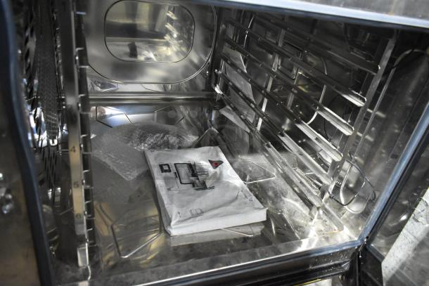 Convotherm stainless steel combi convection oven, interior view. Issue: door does not close. Manual visible inside.