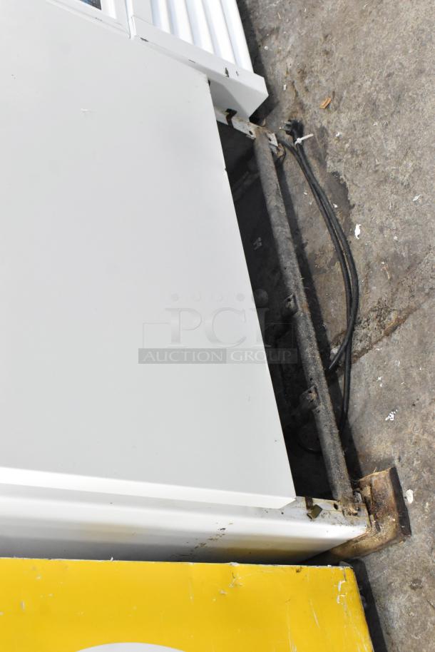 Sears Coldspot metal single door reach-in freezer, 115 volts, 1 phase; visible rust and wear on edges, indicating use.