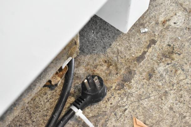 Sears Coldspot metal single door reach-in freezer, 115 volts, 1 phase; visible power plug and cable on a worn surface.