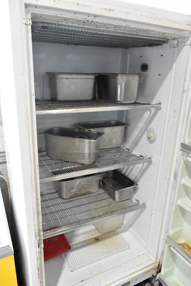 Sears Coldspot metal single door reach-in freezer, 115 volts, 1 phase, showing metal shelving and some wear inside.