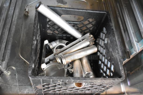 Box of miscellaneous stainless steel parts, including pipes and fittings, inside a commercial oven.