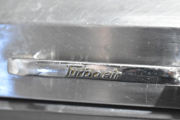 Turbo Air TPR-67SD-D4 stainless steel commercial pizza prep table handle, model embossed with brand logo.