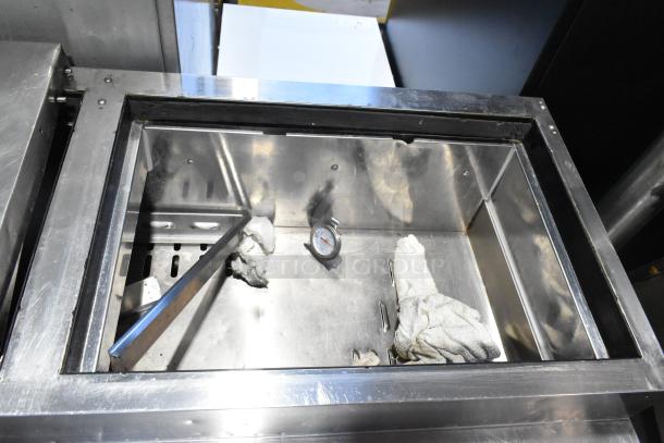 Turbo Air TPR-67SD-D4 stainless steel pizza prep table interior, showing clean surface, thermometer, and cloths.