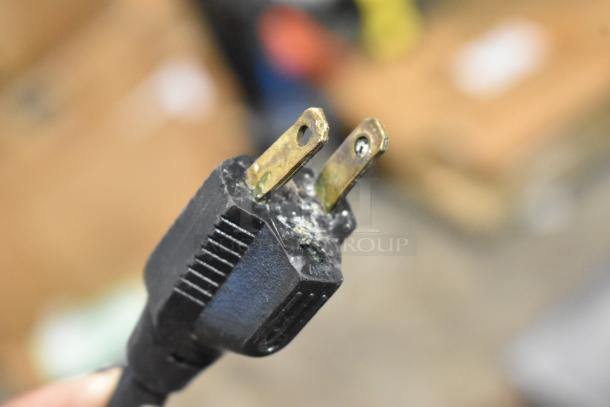 Close-up of a damaged electrical plug from a Varimixer W20 commercial mixer, showing melted plastic and corrosion on the prongs.