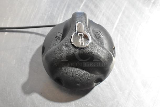 Black fuel cap with chrome lock, textured finish, symbols for lock and unlock. Part of auction set including Grand Sport Pad.