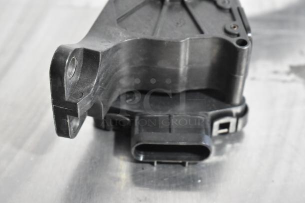 Close-up of a black plastic automotive part, in used condition, with connectors and attachments visible. Part of a 4-item lot.