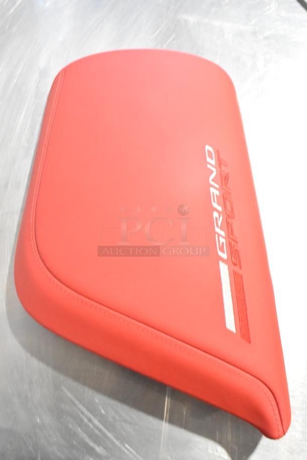 Red Grand Sport pad with embroidered logo, sleek design. Part of a lot of four items, enhancing bid value.
