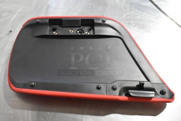 Black and red Grand Sport pad, gently used, showing fastening elements, on a metallic surface.