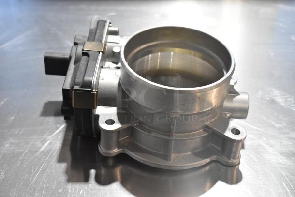 Metal unit, circular metal component, possibly an automotive part, with visible connectors; appears in good condition.