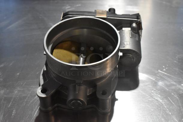 Metal unit with circular opening and attached component, in good condition. Features visible fasteners and metallic finish.