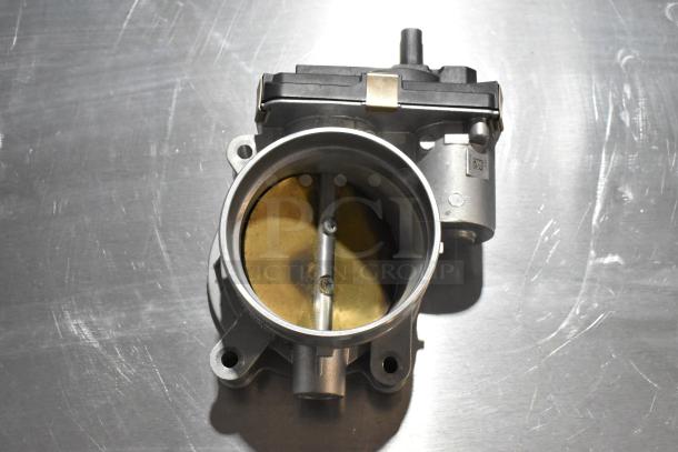 Metal unit with circular opening, featuring screws and a valve. Appears in good condition, with possible industrial use.