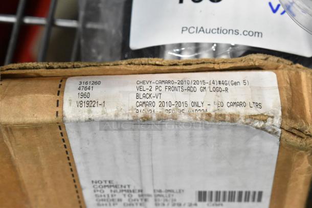 Auction item box with label for Chevy Camaro 2010-2015, 2-piece fronts, GM logo, black, by Lloyd Mats, noting it's new scratch and dent condition.