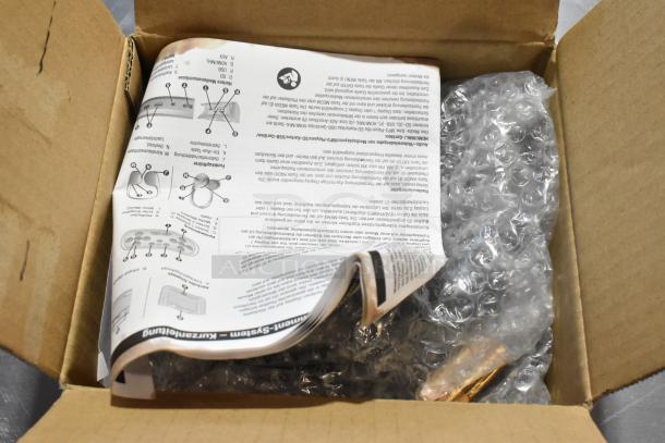 Open cardboard box with GM metal part, instruction manual, and bubble wrap. Item appears new, suggesting valuable collectible.