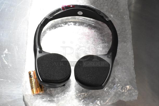 Black over-ear headphones with foam ear pads, shown with two AA batteries. Headphones labeled "Made in China."