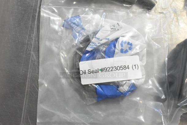 Packaged oil seal with label "#92230584", part of auction including oil additive and gear kit. New condition.