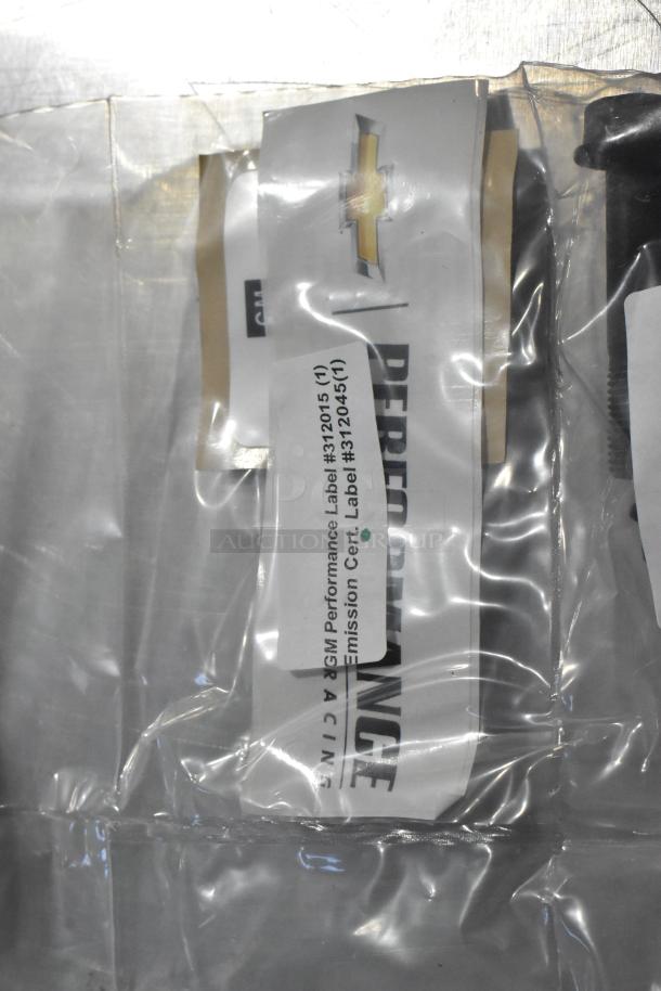 Three automotive items in sealed packaging including oil additive, oil seal, and gear kit; GM Performance label #3120451 visible.