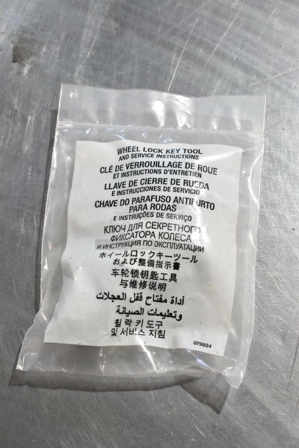 Sealed bag with wheel lock key tool and multilingual service instructions. Code: 079934. Includes 4 hubcap bolt sets.