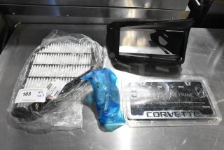 Set of three items: a vent, a sealed air filter, and a Corvette license plate frame. Includes auction tag "103 QTY VX3."