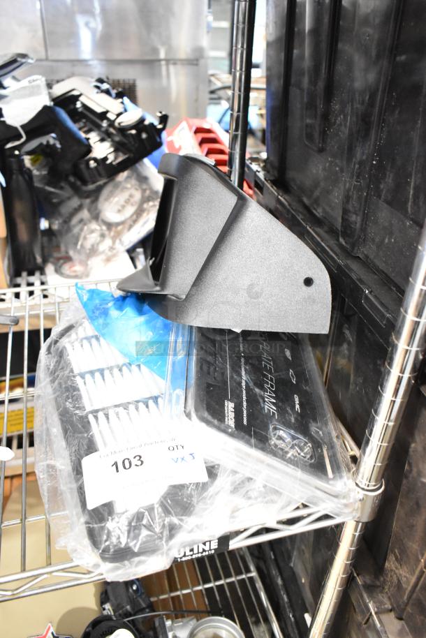Three items on a shelf: a vent, a branded license plate frame in packaging, and a blue wrapped item. Tag reads "103 QTY VX3."
