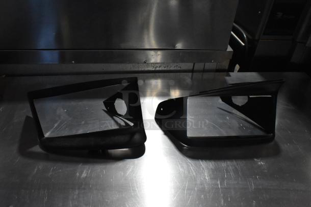 Black license plate frame and vent set on metal surface; modern design, unknown condition, auction lot.