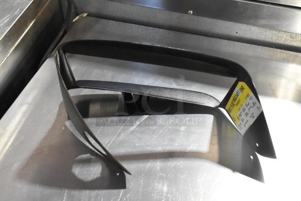 Three automotive items including a black vent and a license plate frame on a metal surface; label with item details visible.