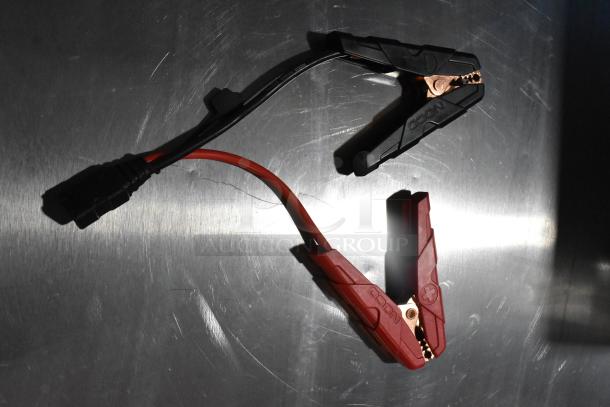 NOCO GB40 Genius Boost battery jump starter cables, black and red, in good condition, on a metallic surface.
