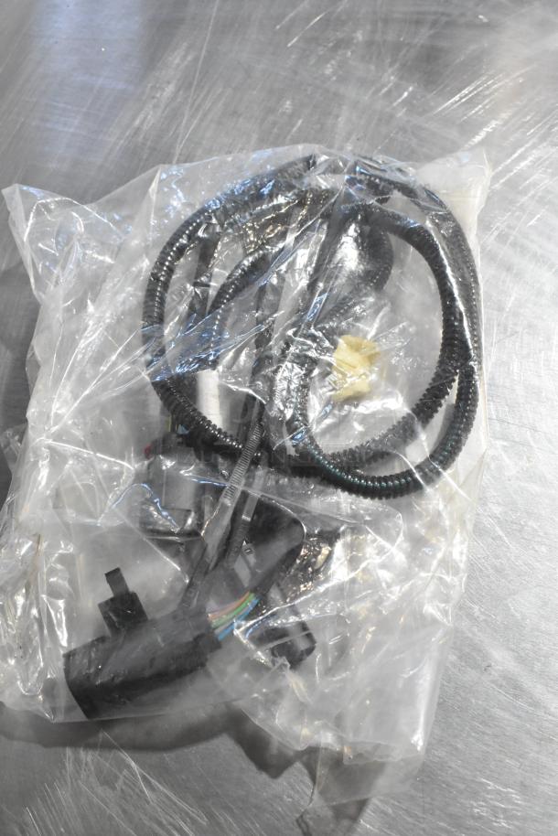 Plastic bag containing three items, including a coiled black wire and connectors, unopened, good condition.