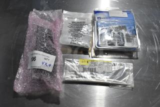 4 items including GM wheel locks, A/C and heat panel, packaged and labeled in bags on a metal surface.