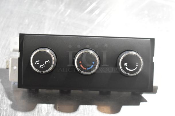 GM A/C and heat control panel with three knobs, black finish, chrome accents.