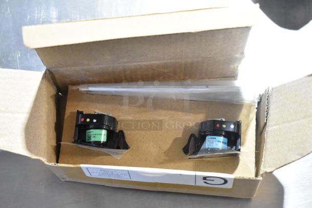 Box containing two LED puddle lights with green labels and part numbers, housed in original packaging.