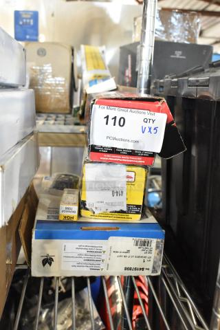 Stack of automotive parts boxes, including NGK BKR5EGP bulb, Hawk ceramic brake pads, and GM brake pads. Auction label visible.
