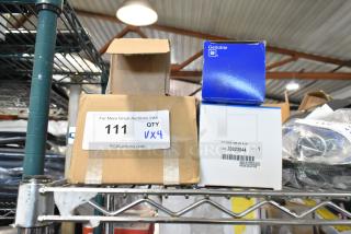 Four various auto parts boxes, including GM 25664746, Corvette LT1, GM brake light piece, and X34-122-B1, stacked on a shelf.