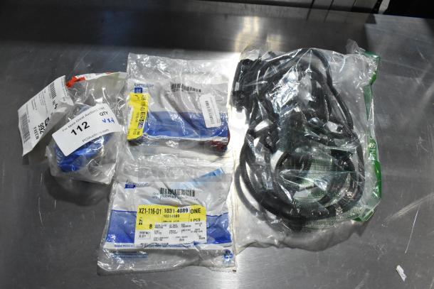 Four various GM automotive parts, including GM X21-116-D1 and GM reflector part, in original packaging with labels.