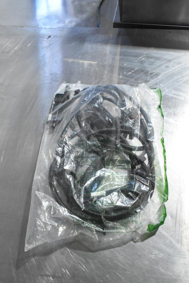 Bagged coiled cable, possibly automotive, with visible text "GM X21-116-D1". Appears new, in clear plastic packaging.