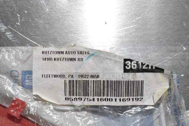 Plastic-wrapped GM reflector part, with Kutztown Auto Sales label, barcode 058975416001169192, some wear visible.