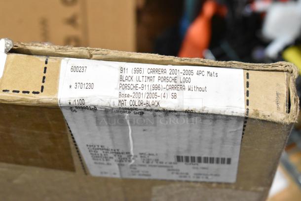 Box labeled "Porsche 911 Carrera 2001-2005 4PC Mats, Black Ultimat Porsche Logo." Contains car mats for auction.