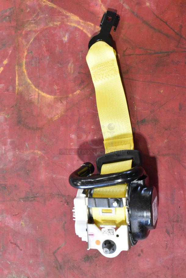 Yellow seat belt assembly on red background, featuring metal buckle, black winding mechanism, and white labels with codes.