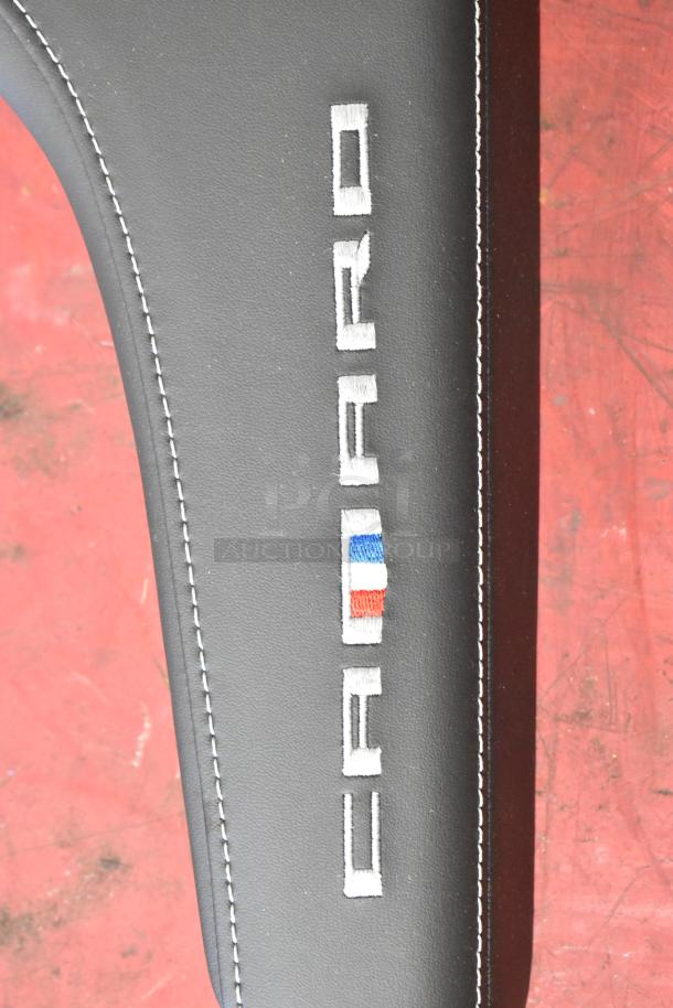 Black Camaro pad with embroidered logo and stitching. Clean condition. Perfect for car interior enhancement.