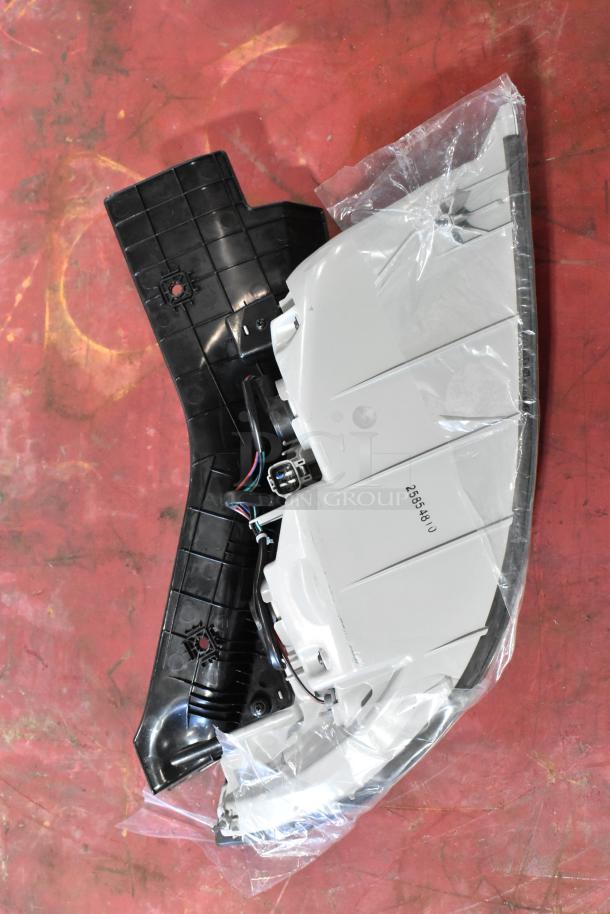 Brake light assembly featuring a black and white plastic casing. Includes wiring and visible marking "25554948". New condition.