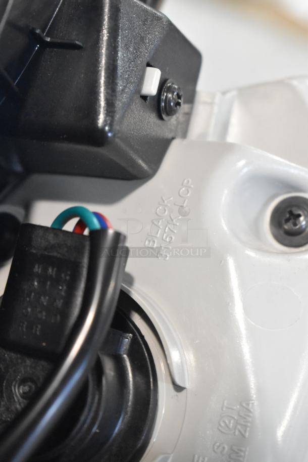 Close-up of a black and white automotive component, showing wires and markings "BLACK 3157K LCP". Part of an auction lot.