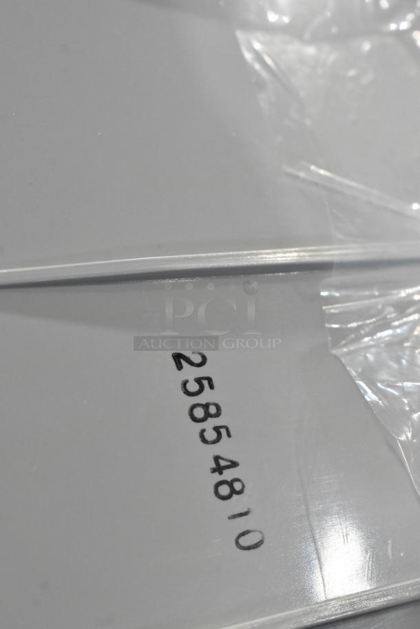 Clear plastic-wrapped surface with visible marking "25854810." Part of an auction lot including brake lights.