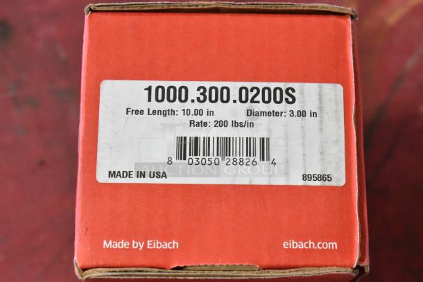 Red box labeled "1000.300.0200S Coil" by Eibach. Specs: 10" length, 3" diameter, 200 lbs/in rate. Made in USA.