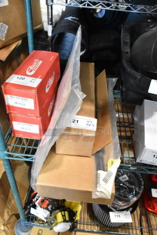 Four various items, including a GM 23360288 wiper blade and Eibach boxes, on a metal shelf. Appears new in packaging.