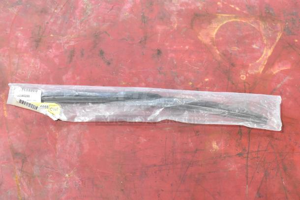Sealed GM 23360288 wiper blade in clear packaging on red surface, barcode and label visible, excellent condition.