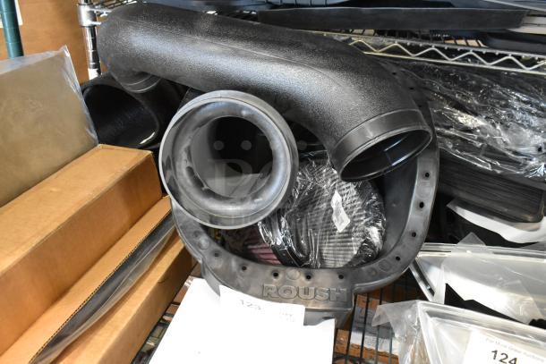 Four automotive parts including a 997-951F filter and Roush intake components, packed on a shelf, new condition.