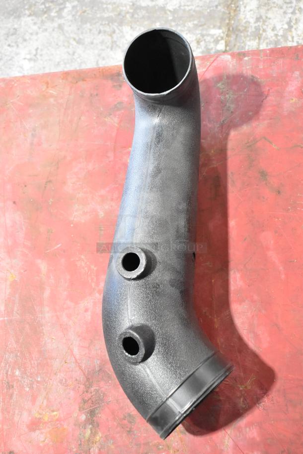 Black plastic automotive part, possibly an air duct, with two tube connections on a red surface. Part of a lot including a 997-951F filter.
