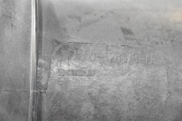 Close-up of an item showing a part number "H1550-12B579-AA" on a gray surface. Part of a lot including a 997-951F filter.