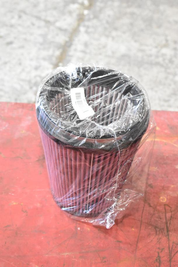 Plastic-wrapped cylindrical 997-951F filter on a red surface, brand label visible.