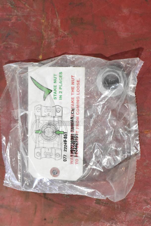 Plastic bag containing a metal part with a label showing staking instructions and part number 077 22249-951.